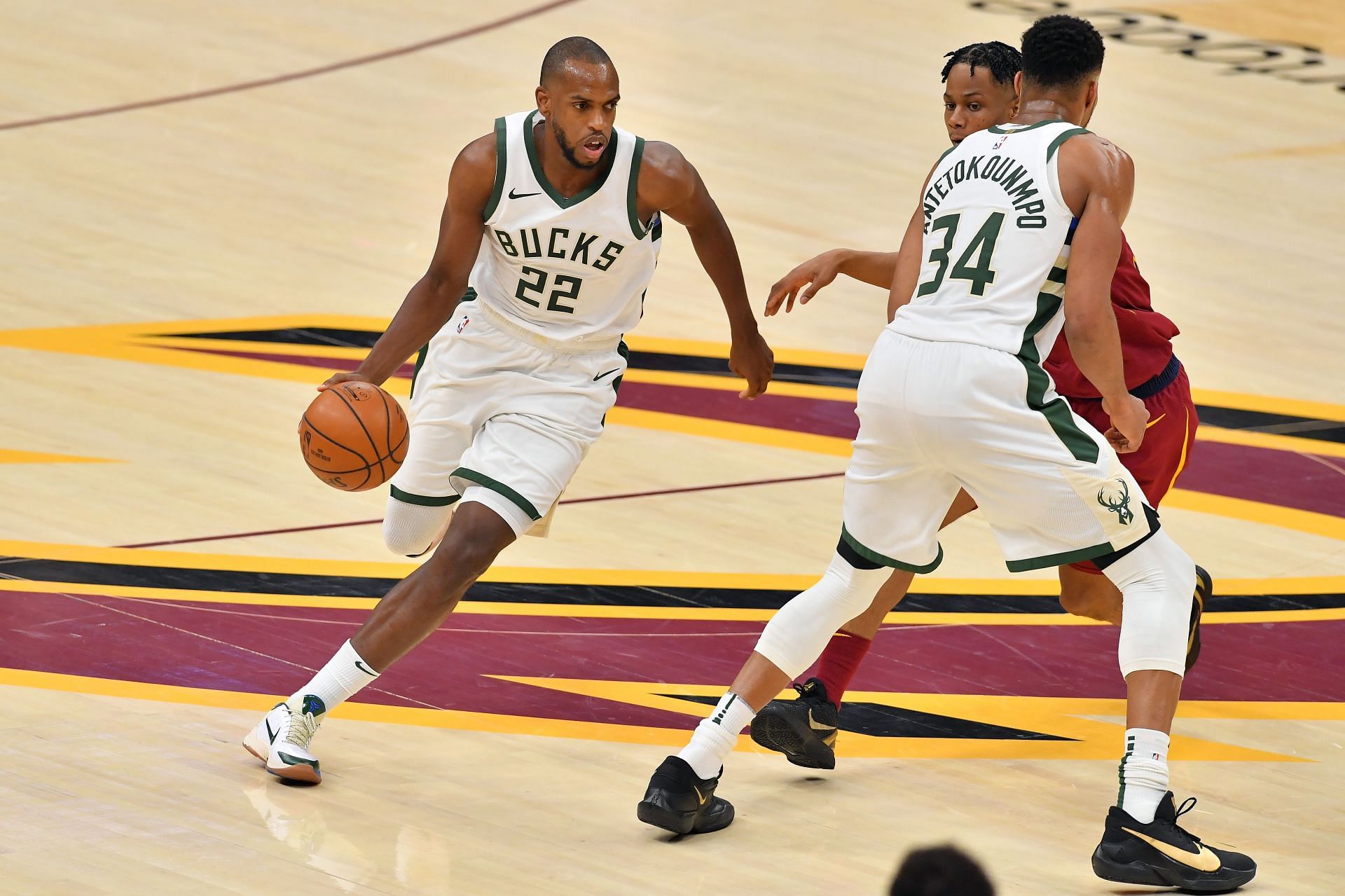 Khris Middleton #22 of the Milwaukee Bucks drives the ball against Isaac Okoro #35 of the Cleveland Cavaliers and teammate Giannis Antetokounmpo #34 in the third quarter at Rocket Mortgage Fieldhouse on February 05, 2021 in Cleveland, Ohio.