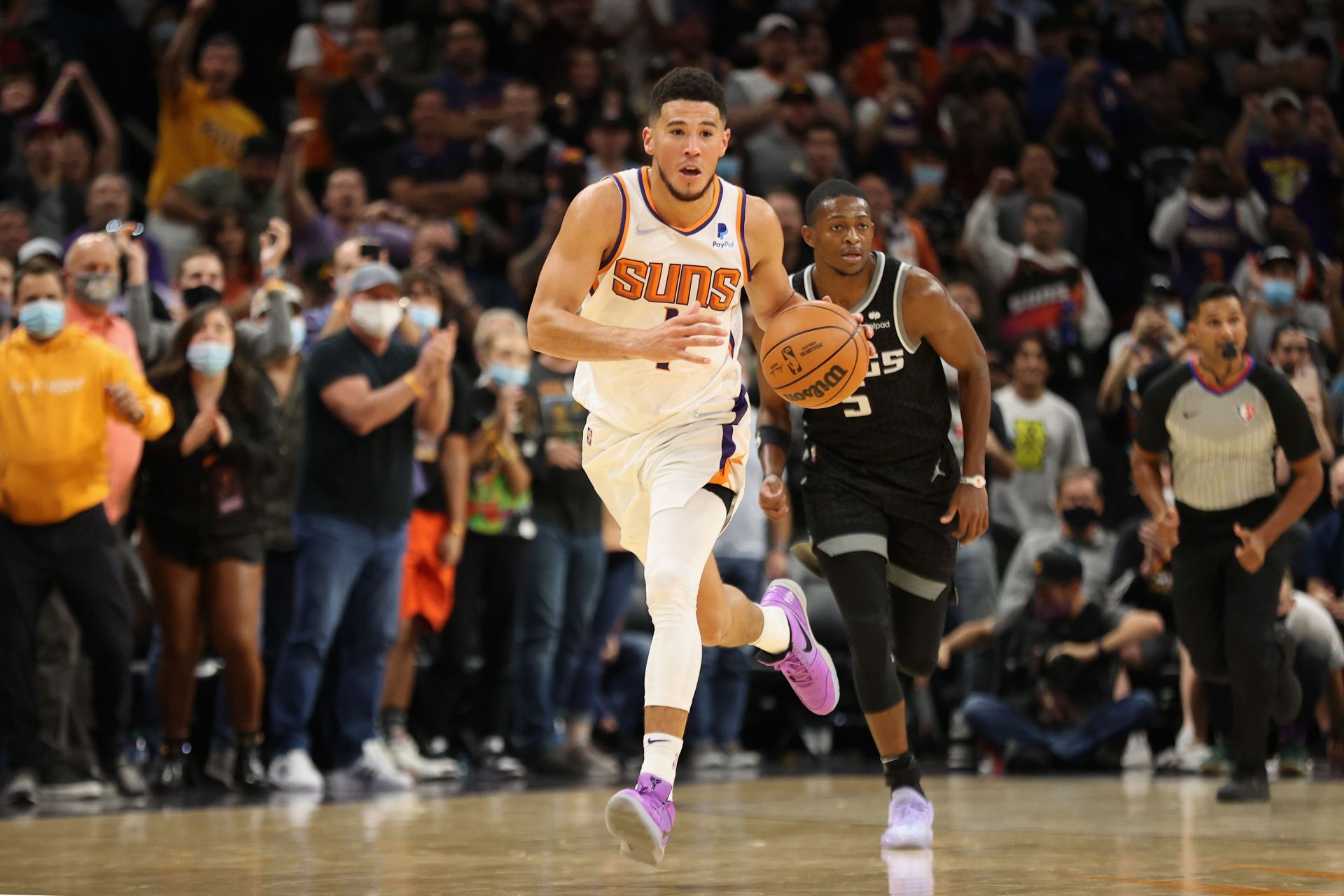 Devin Booker #1 of the Phoenix Suns drives the ball past De'Aaron Fox #5 of the Sacramento Kings during the second half of the NBA game at Footprint Center on October 27, 2021 in Phoenix, Arizona.