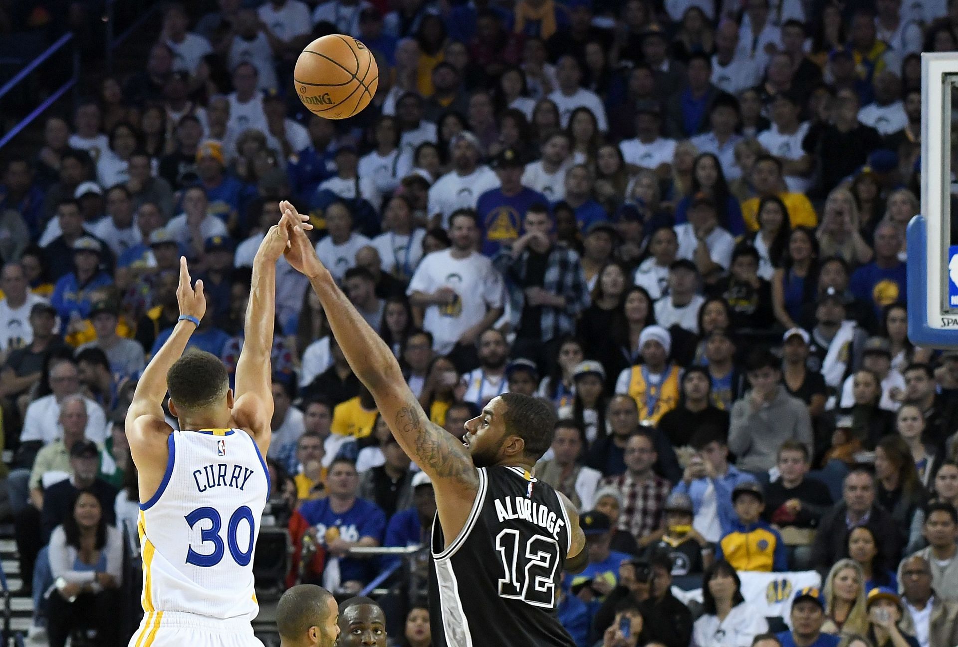 Stephen Curry of the Golden State Warriors shoots over LaMarcus Aldridge of the San Antonio Spurs.