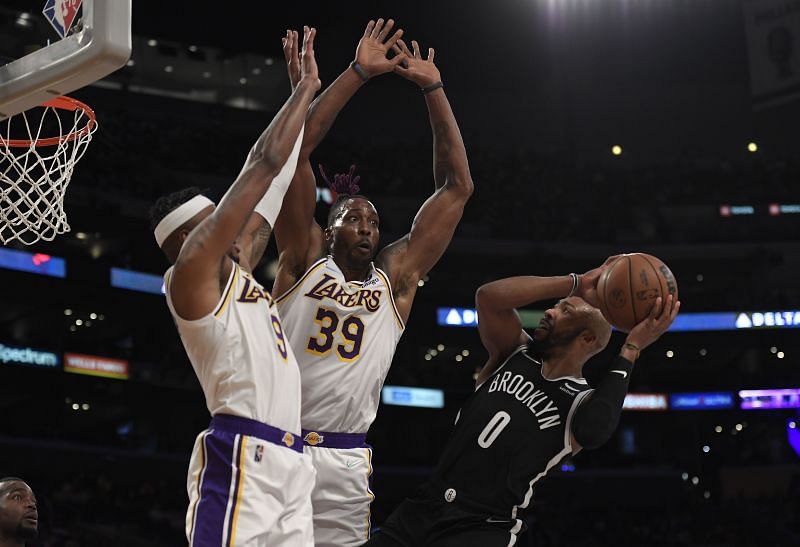 Dwight Howard and Kent Bazemore of the LA Lakers go up to block a layup attempt