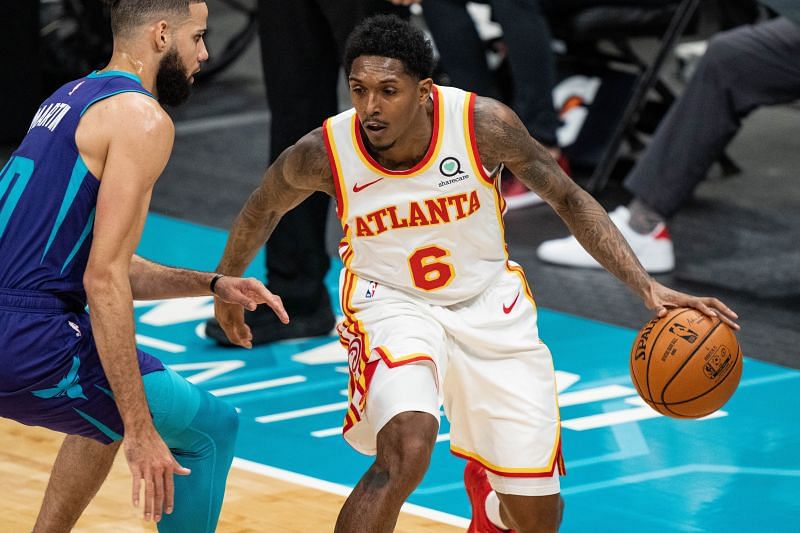 Lou Williams #6 of the Atlanta Hawks brings the ball up court while guarded by Caleb Martin #10 of the Charlotte Hornets in the second quarter during their game at Spectrum Center on April 11, 2021 in Charlotte, North Carolina.