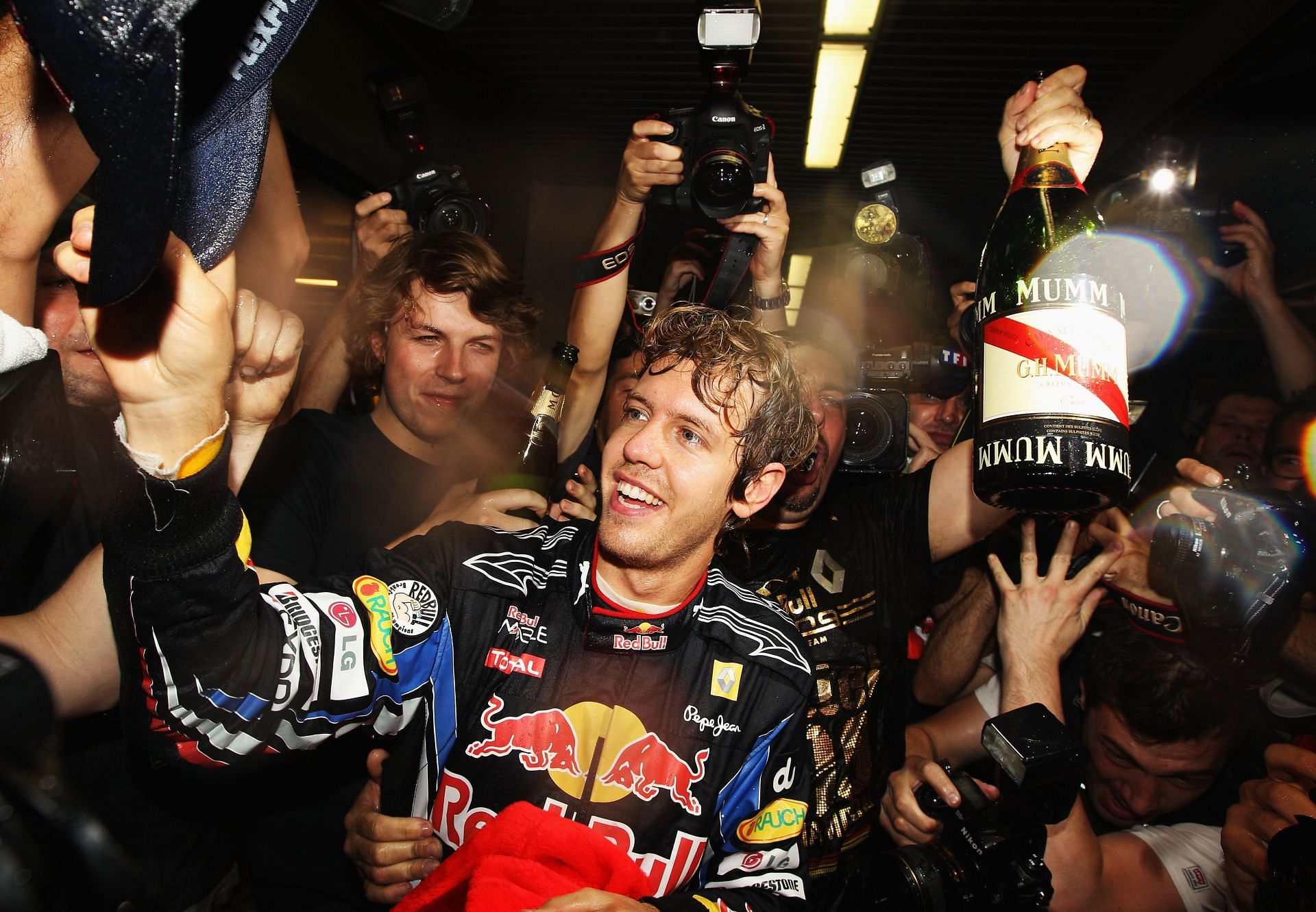 Race winner and 2010 World Champion Sebastian Vettel of Red Bull Racing celebrates with team mates in their team garage following the 2010 Abu Dhabi Grand Prix at the Yas Marina Circuit, United Arab Emirates. (Photo by Paul Gilham/Getty Images)