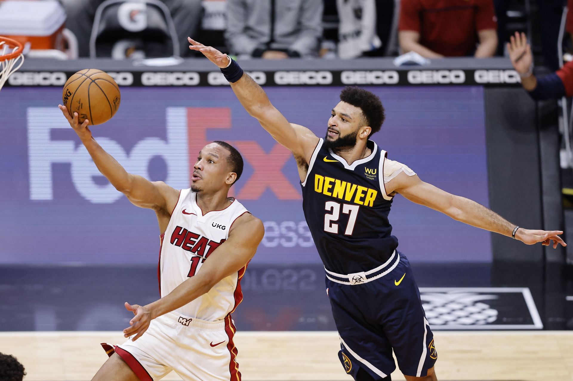 Avery Bradley attempts a layup while avoiding a block from Jamal Murray.