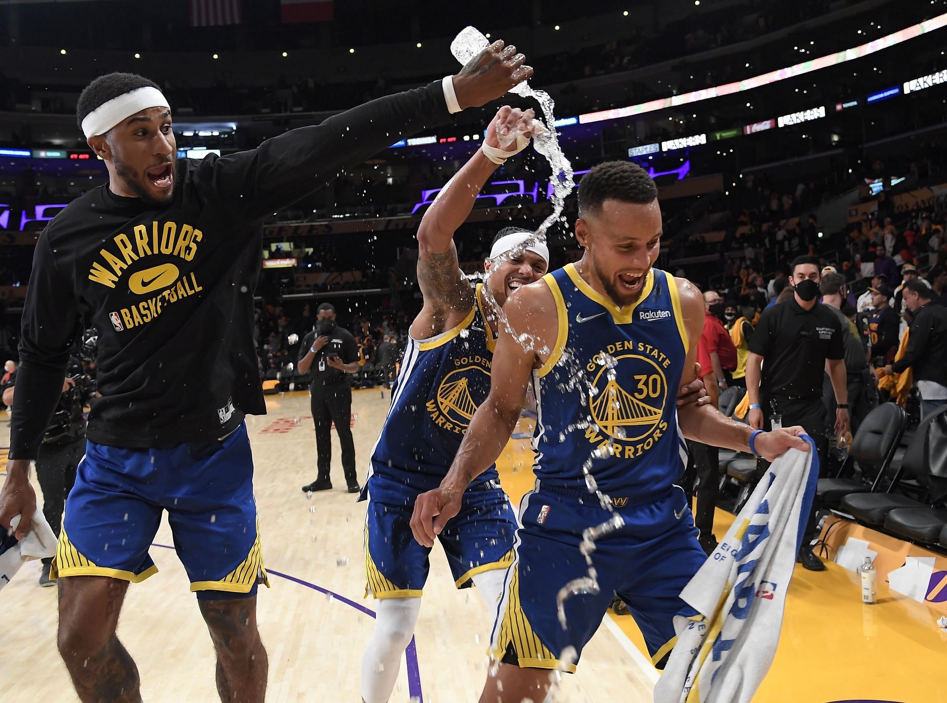 Gary Payton II and Damion Lee of the Golden State Warriors shower Stephen Curry with water
