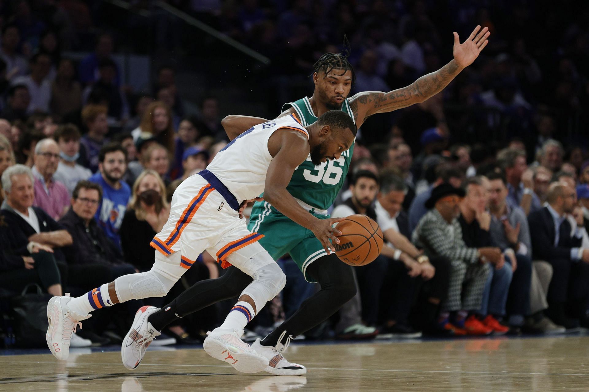 New York Knicks guard Kemba Walker dribbling past Marcus Smart