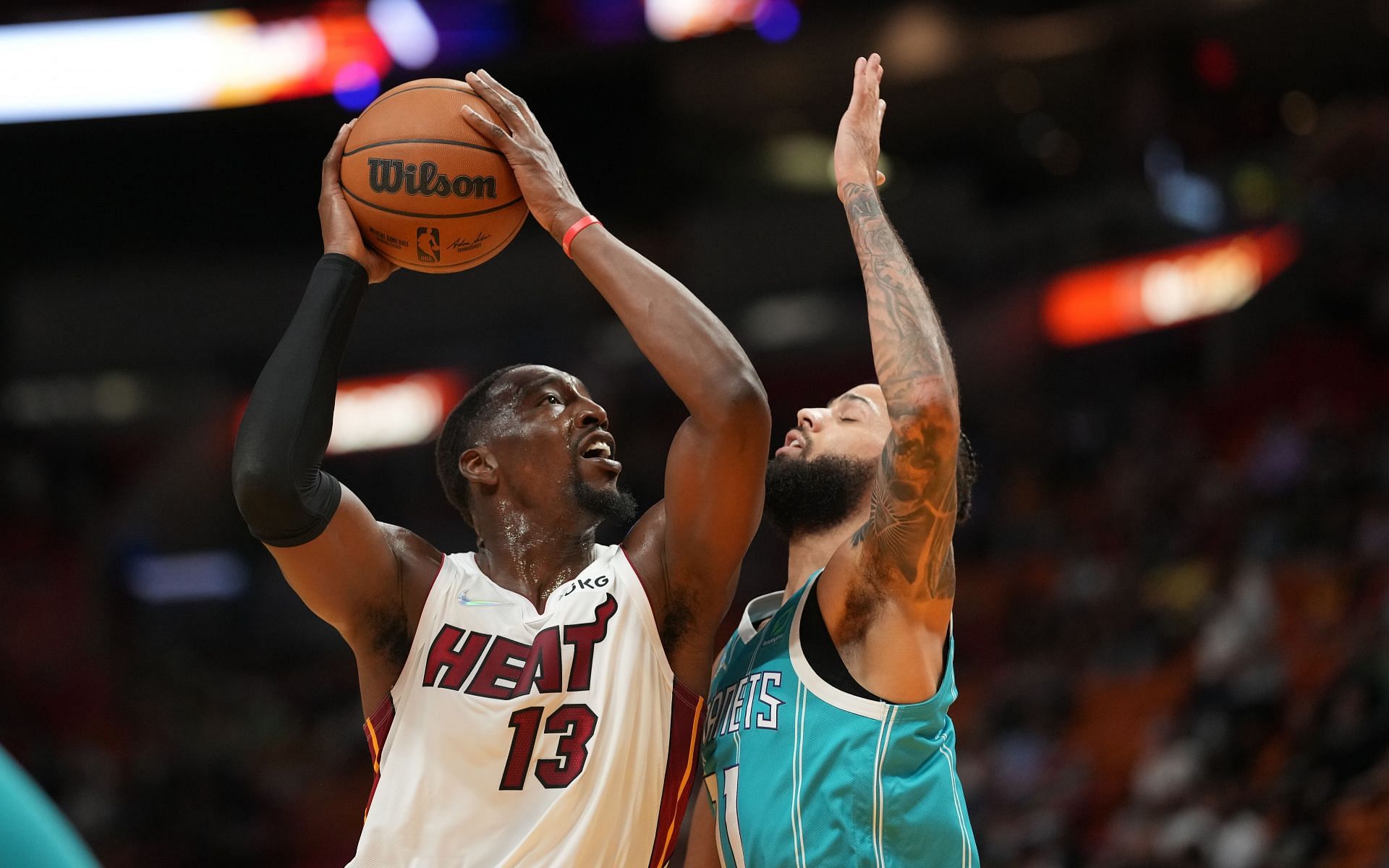 Bam Adebayo #13 of the Miami Heat drives to the basket against the Cody Martin #11 of the Charlotte Hornets int he first quarter during the preseason game at FTX Arena on October 11, 2021 in Miami, Florida.