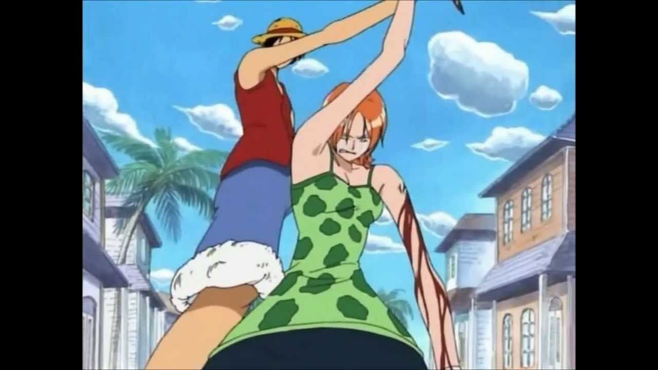 Nami seen here sadly stabbing her shoulder where her Arlong Pirates crew tattoo is before Luffy steps in to stop her. (Image via Toei Animation)