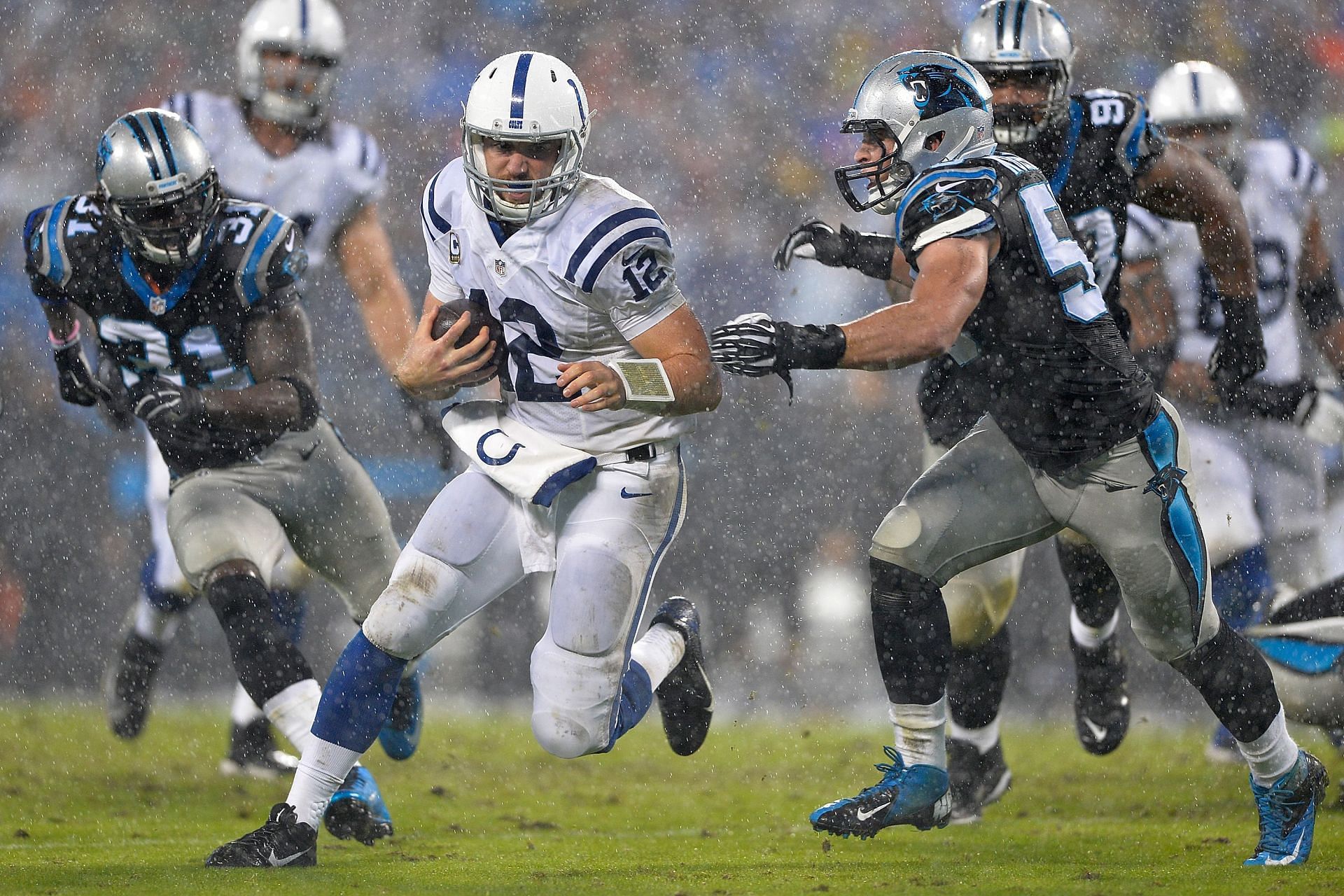 Andrew Luck of Indianapolis Colts pursued by Luke Kuechly of Carolina Panthers