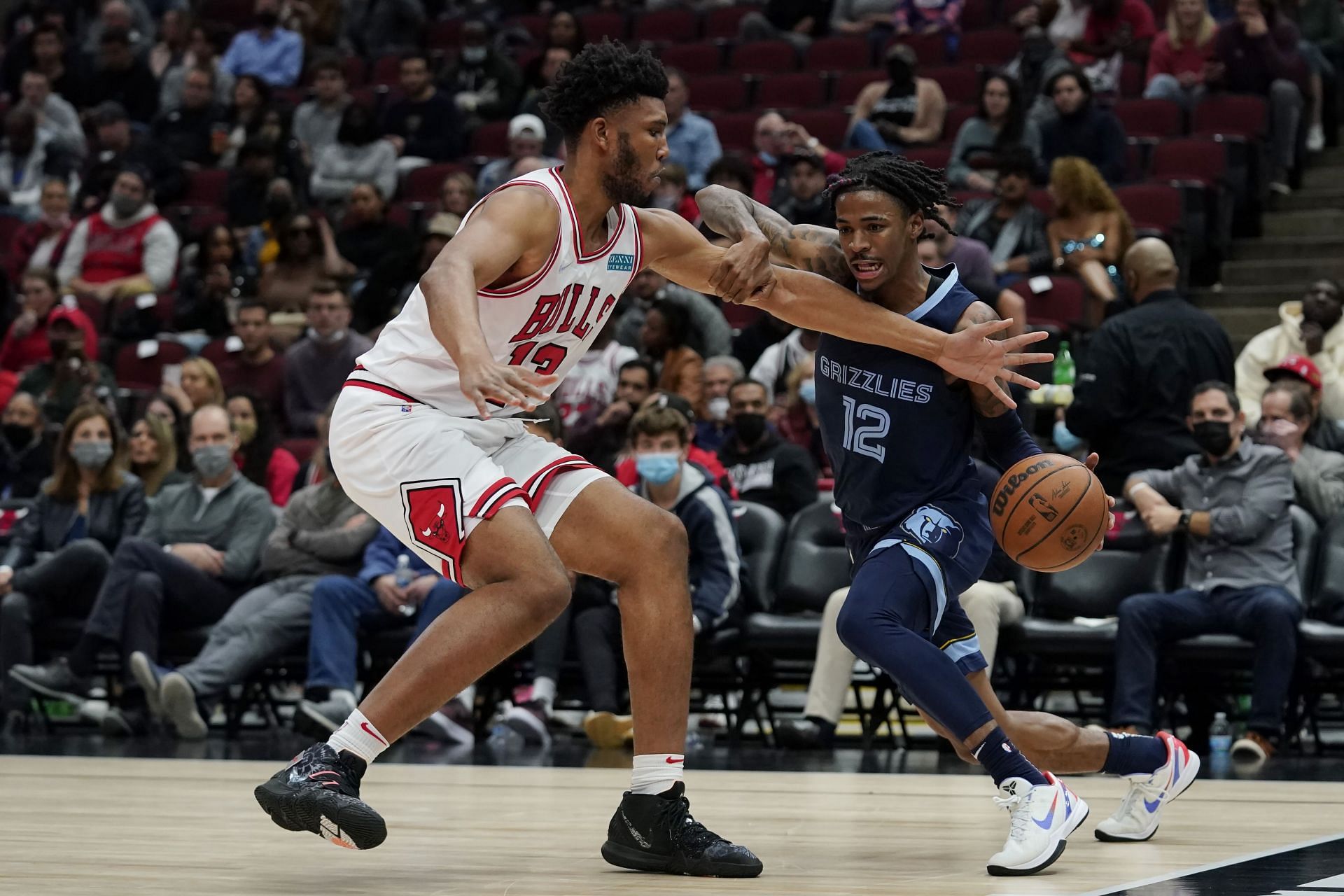 Ja Morant #12 of the Memphis Grizzlies dribbles the ball against Tony Bradley #13 of the Chicago Bulls in the second half during a preseason game at United Center on October 15, 2021 in Chicago, Illinois. The Chicago Bulls defeated the Memphis Grizzlies 118-105.