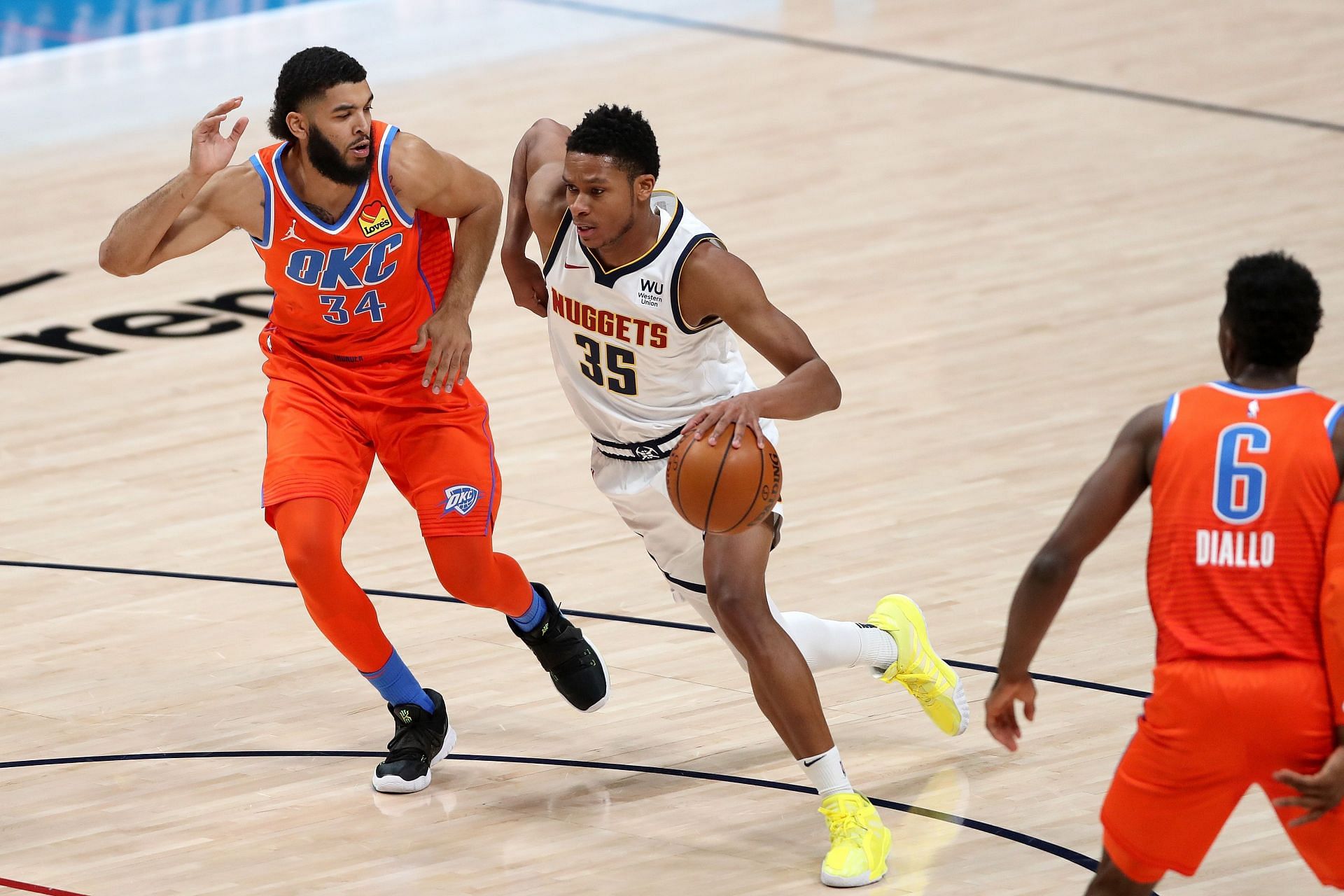 PJ Dozier #35 of the Denver Nuggets drives against Kenrich Williams #34 of the Oklahoma City Thunder in the second quarter at Ball Arena on January 19, 2021 in Denver, Colorado.