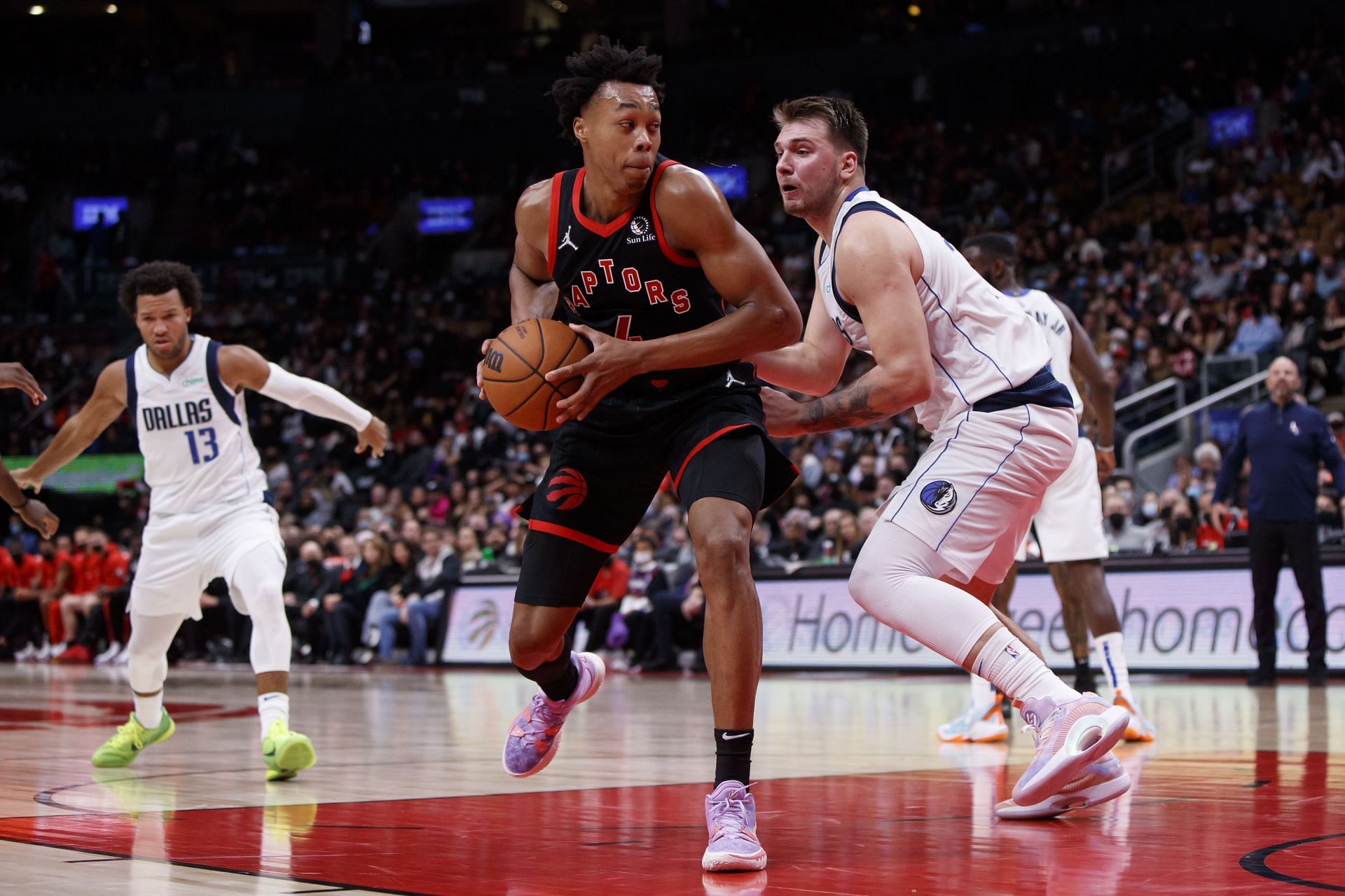 Scottie Barnes #4 of the Toronto Raptors drives against Luka Doncic #77 of the Dallas Mavericks during the second half of their NBA game at Scotiabank Arena on October 23, 2021 in Toronto, Canada.