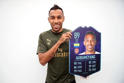 Pierre-Emerick Aubameyang poses with his FIFA card after winning the Premier League's player of the month award in 2018 (Image via EA Sports)