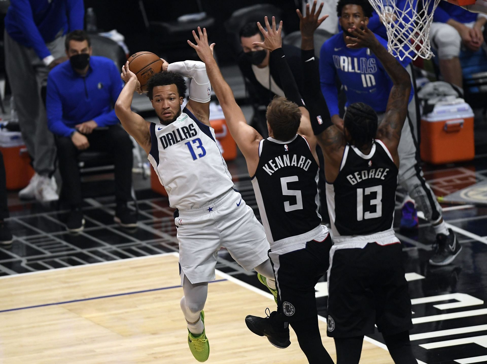 Jalen Brunson #13 of the Dallas Mavericks passes the ball against Luke Kennard #5 and Paul George #13 of the Los Angeles Clippers during the first half of Game Seven of the Western Conference first round series at Staples Center on June 6, 2021 in Los Angeles, California.