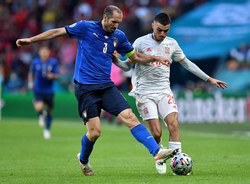 Pedri of Spain is challenged by Giorgio Chiellini of Italy during the UEFA Euro 2020 semi-final