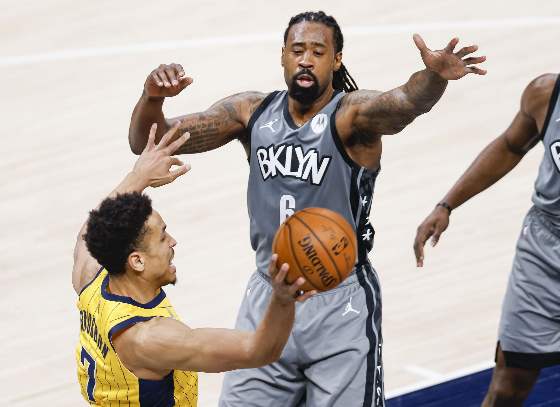 Malcolm Brogdon (#7) of the Indiana Pacers passes the ball around DeAndre Jordan (#6) of the Brooklyn Nets