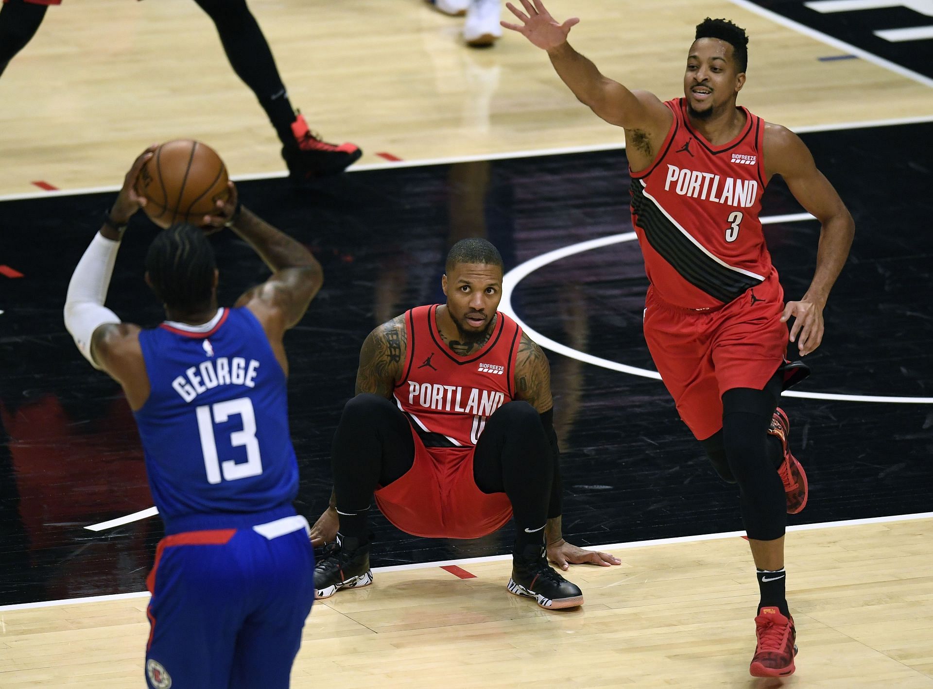 Paul George of the LA Clippers shoots in front of Portland Trail Blazers&#039; Damian Lillard and CJ McCollum.