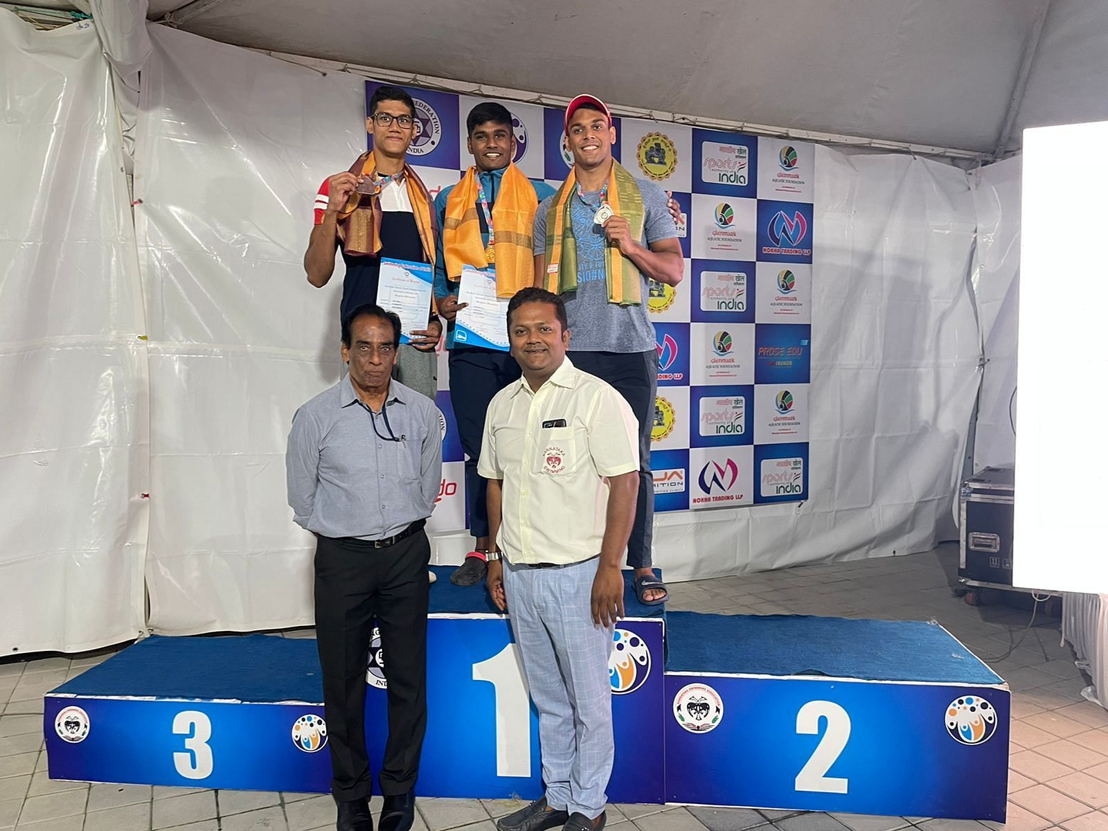 Sambhavv R flanked by Heer Shah (left) and Mihir Ambre at the medal ceremony of 50m freestyle event. (PC: SFI)