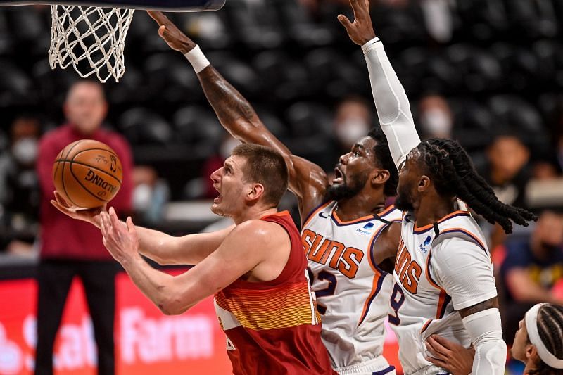 Nikola Jokic #15 of the Denver Nuggets drives to the net under coverage by Jae Crowder #99 and Deandre Ayton #22 of the Phoenix Suns in Game Four of the Western Conference second-round playoff series at Ball Arena on June 13, 2021 in Denver, Colorado.
