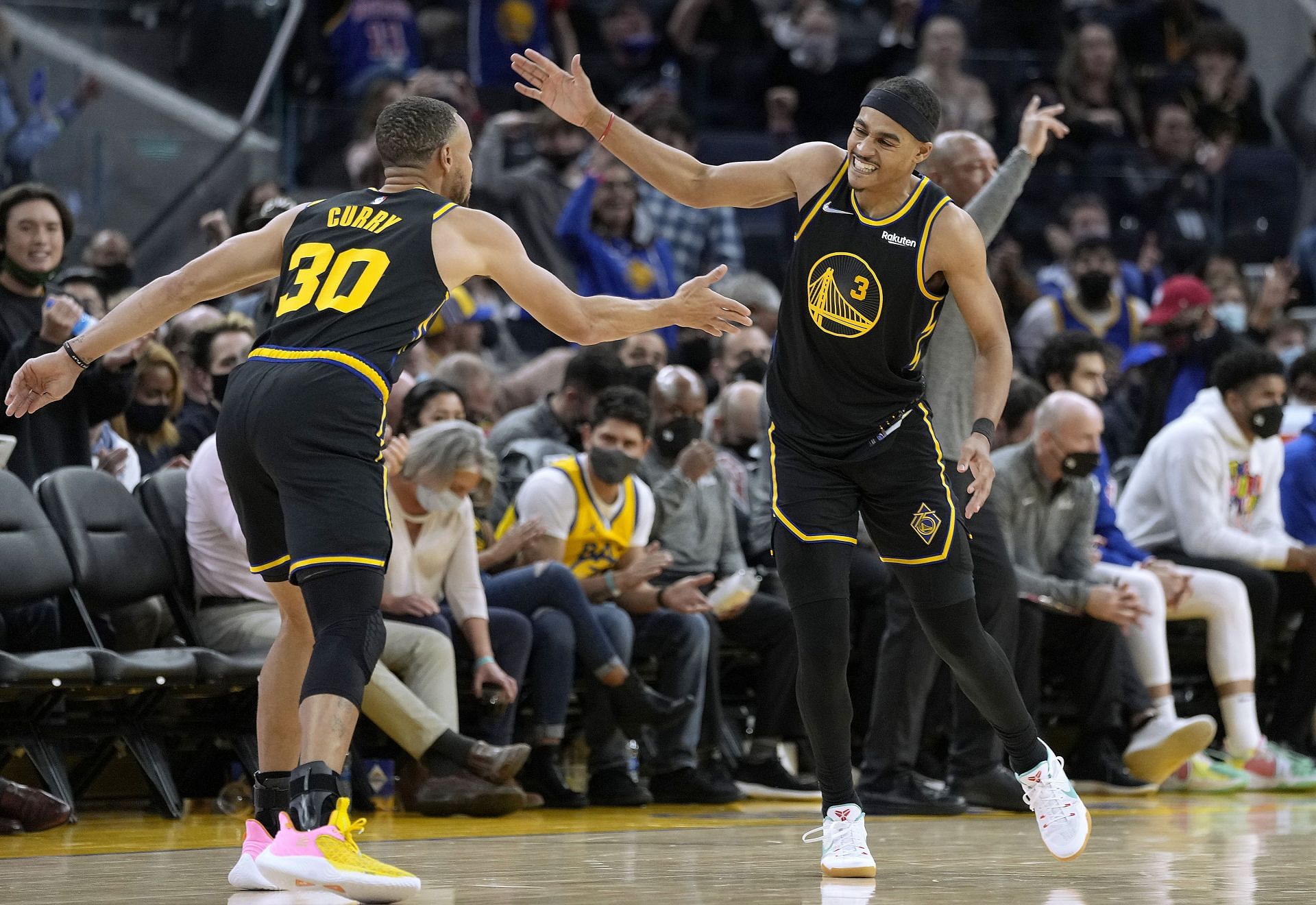 Stephen Curry #30 of the Golden State Warriors celebrates with Jordan Poole #3 after making a three-point shot against the Philadelphia 76ers