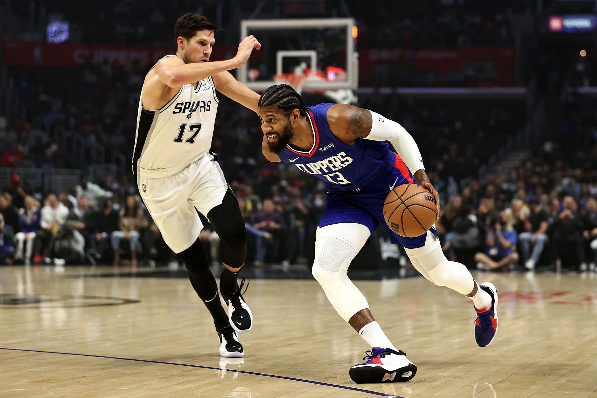 Paul George attempts to drive past a San Antonio Spurs defender