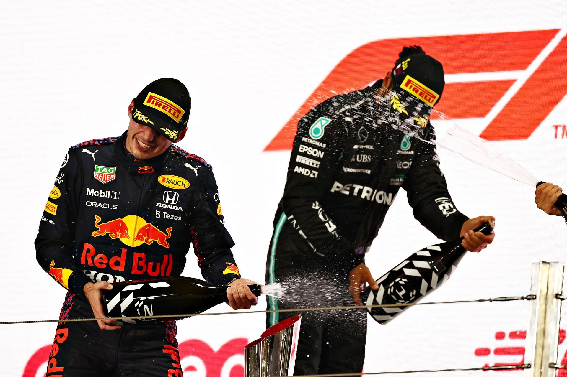 Race winner Lewis Hamilton and second-placed Max Verstappen celebrate on the podium after the 2021 Qatar Grand Prix.