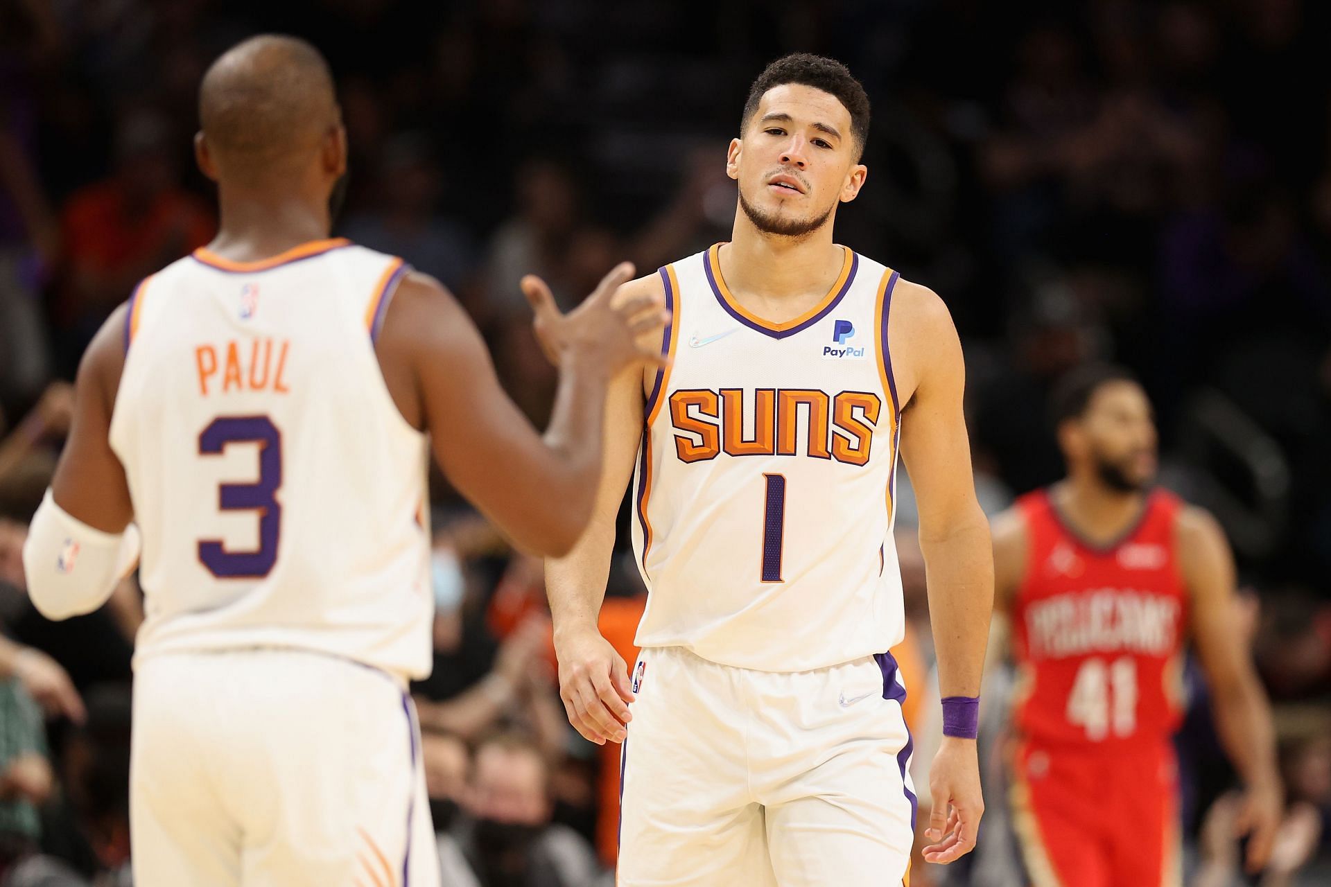 Devin Booker #1 of the Phoenix Suns reacts to Chris Paul #3 after Booker hit a three-point shot against the New Orleans Pelicans