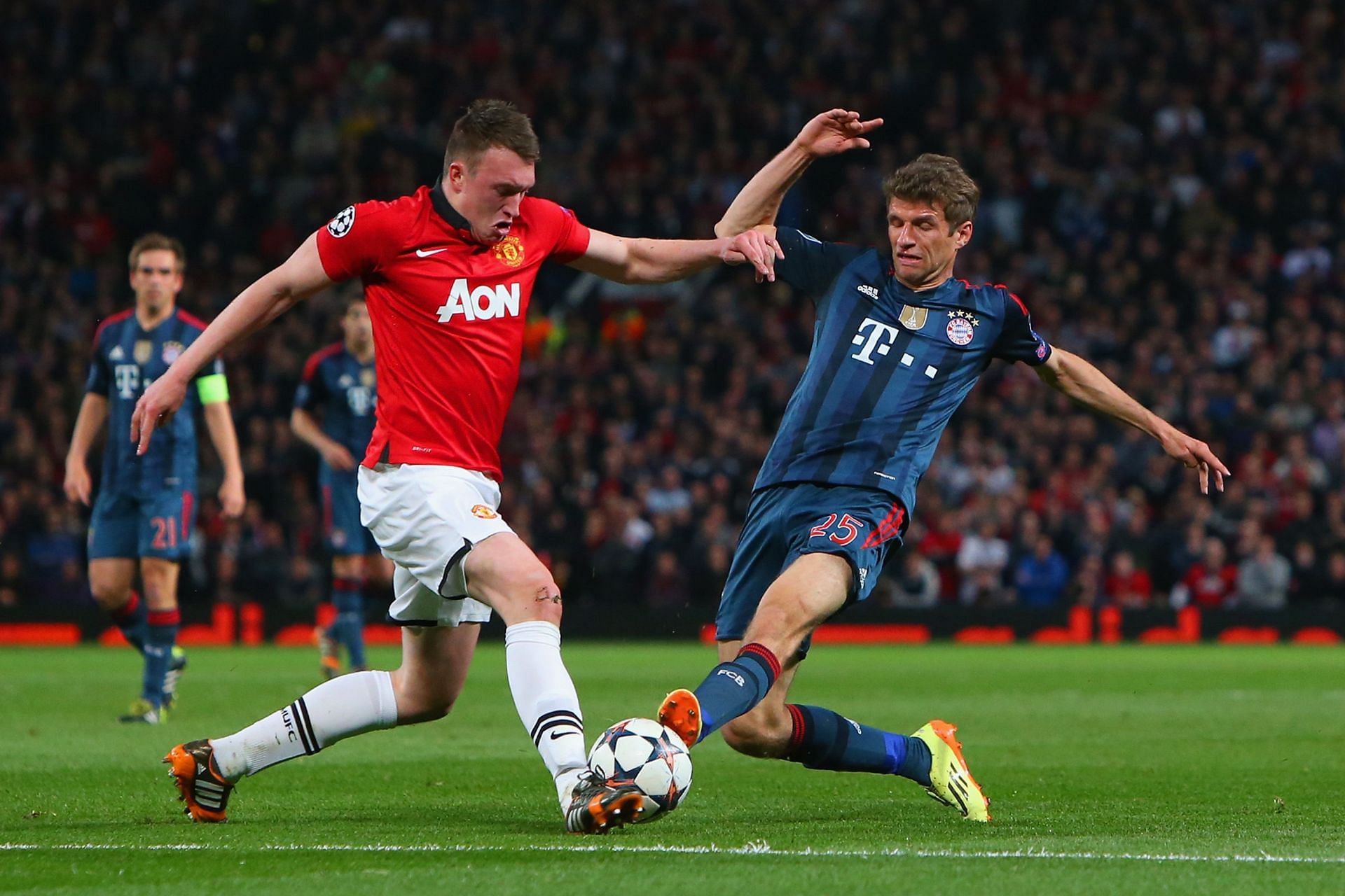 Thomas Muller (R) tackles Manchester United&#039;s Phil Jones