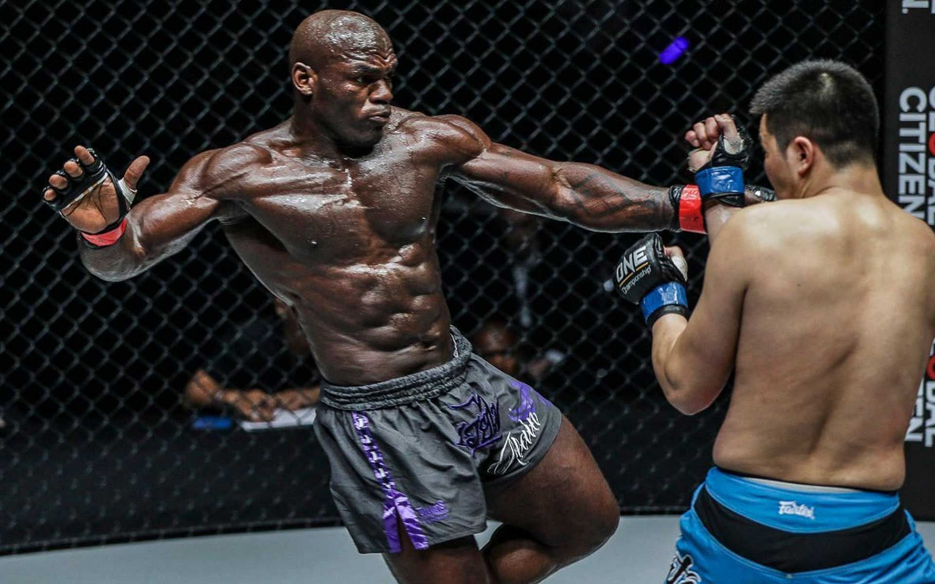 Alain Ngalani (left) delivers a kick to the body against an opponent [Photo courtesy of ONE Championship]
