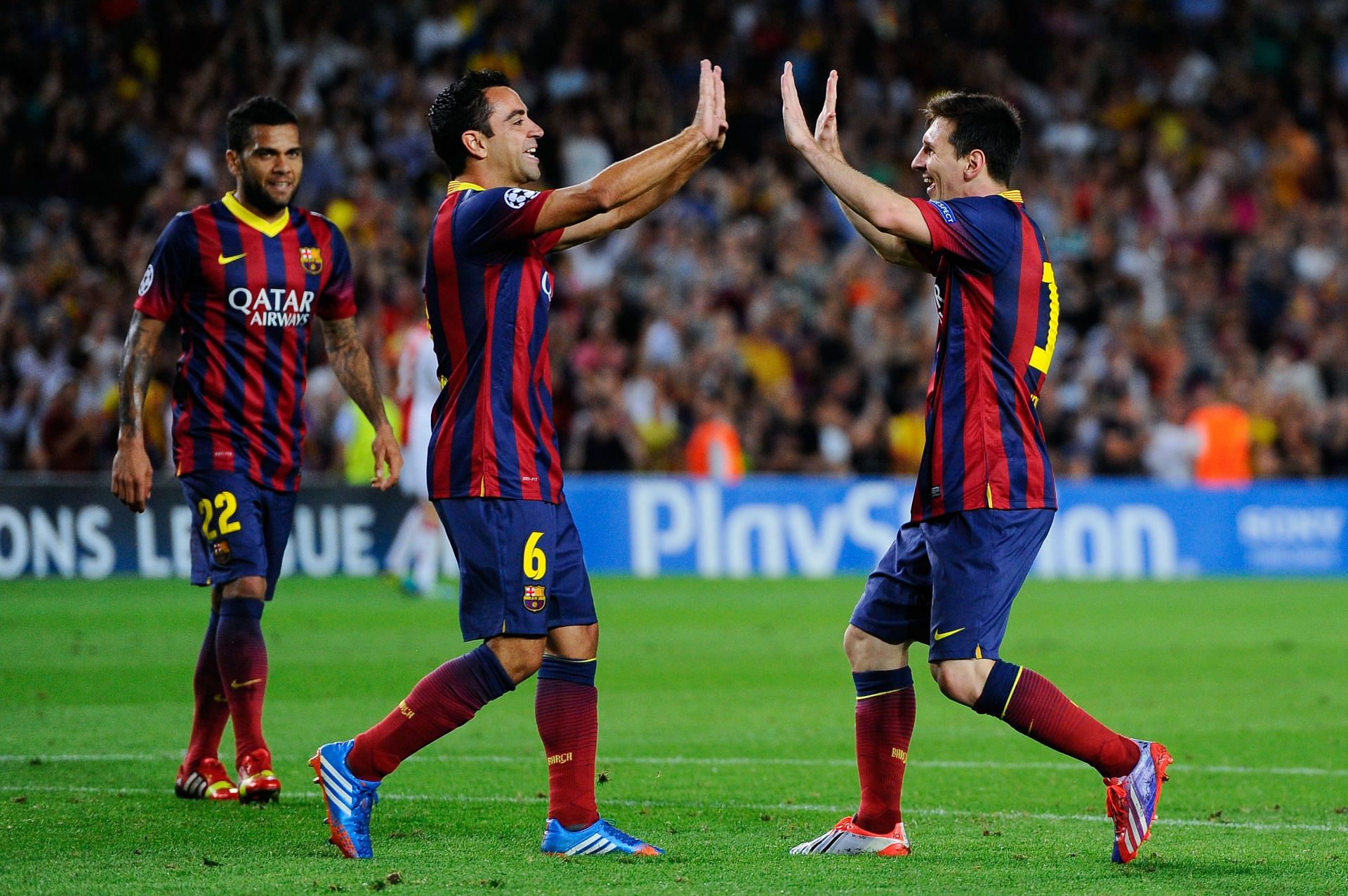 Xavi (centre) and Lionel Messi celebrate a goal during their playing days at FC Barcelona.