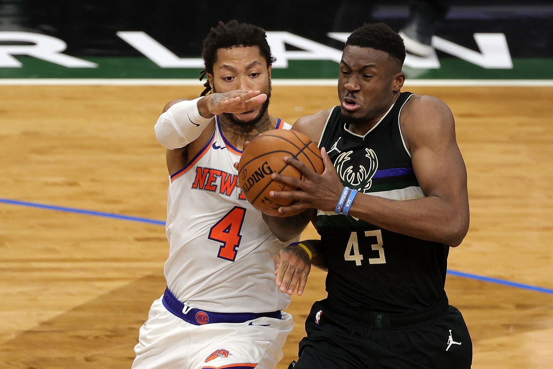 Derrick Rose of the New York Knicks defends Thanasis Antetokounmpo of the Milwaukee Bucks.