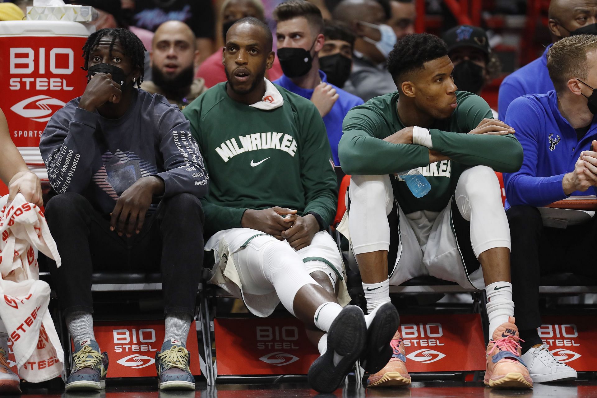 Jrue Holiday, Khris Middleton and Giannis Antetokounmpo watch on during Milwaukee Bucks v Miami Heat game
