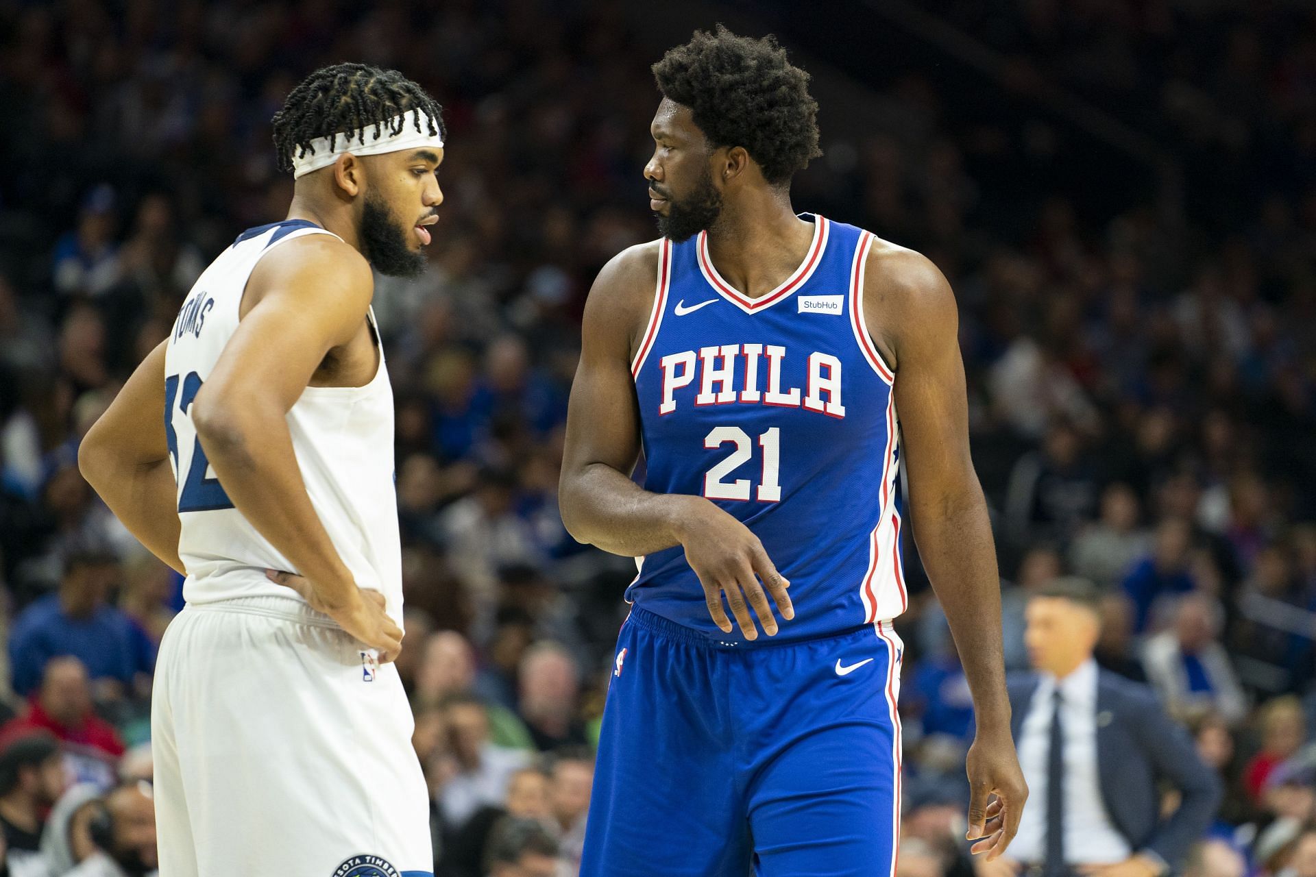 Karl-Anthony Towns and Joel Embiid walk past each other during an NBA game between the Philadelphia 76ers and the Minnesota Timberwolves.