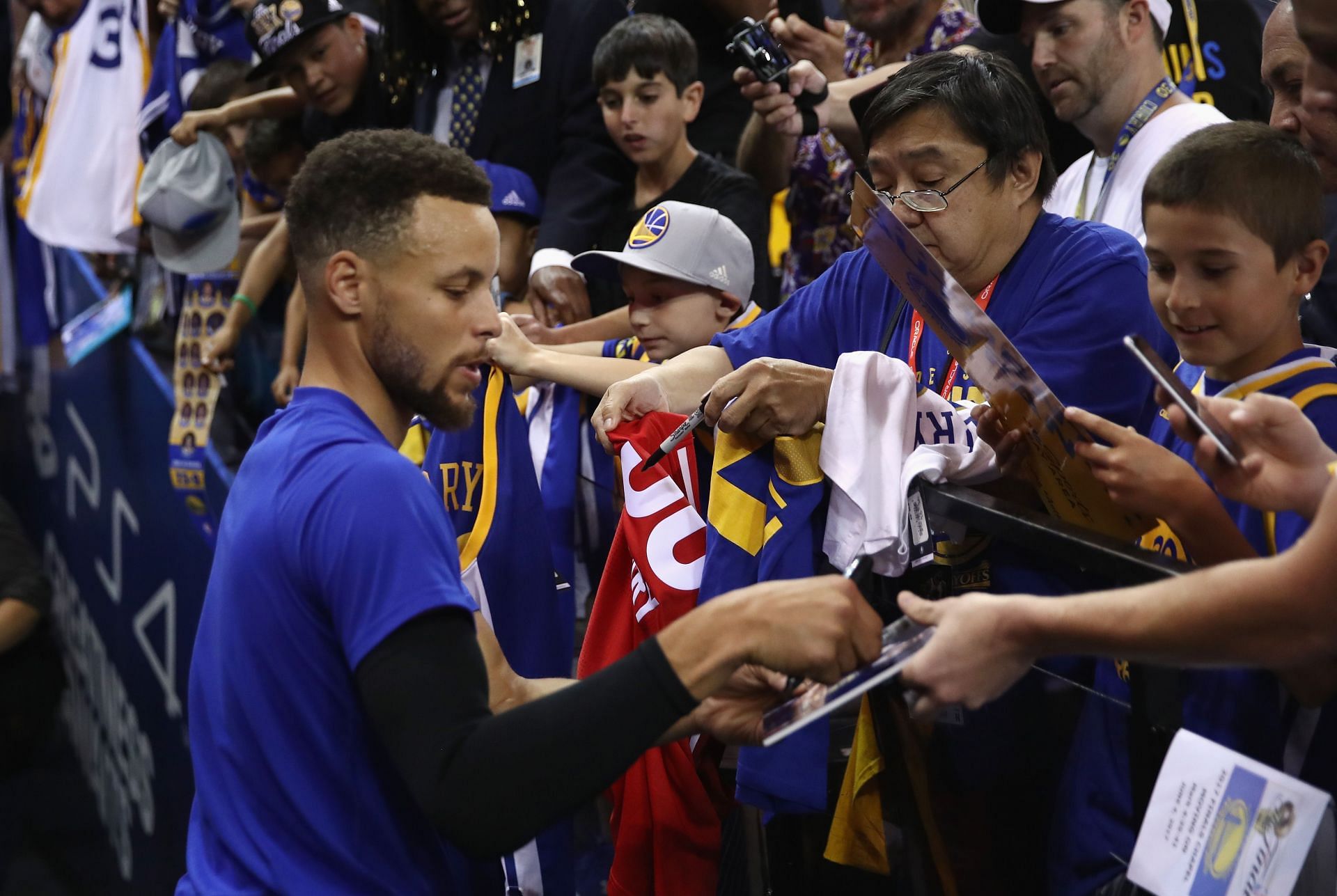 Steph Curry of the Golden State Warriors signs autographs for fans.