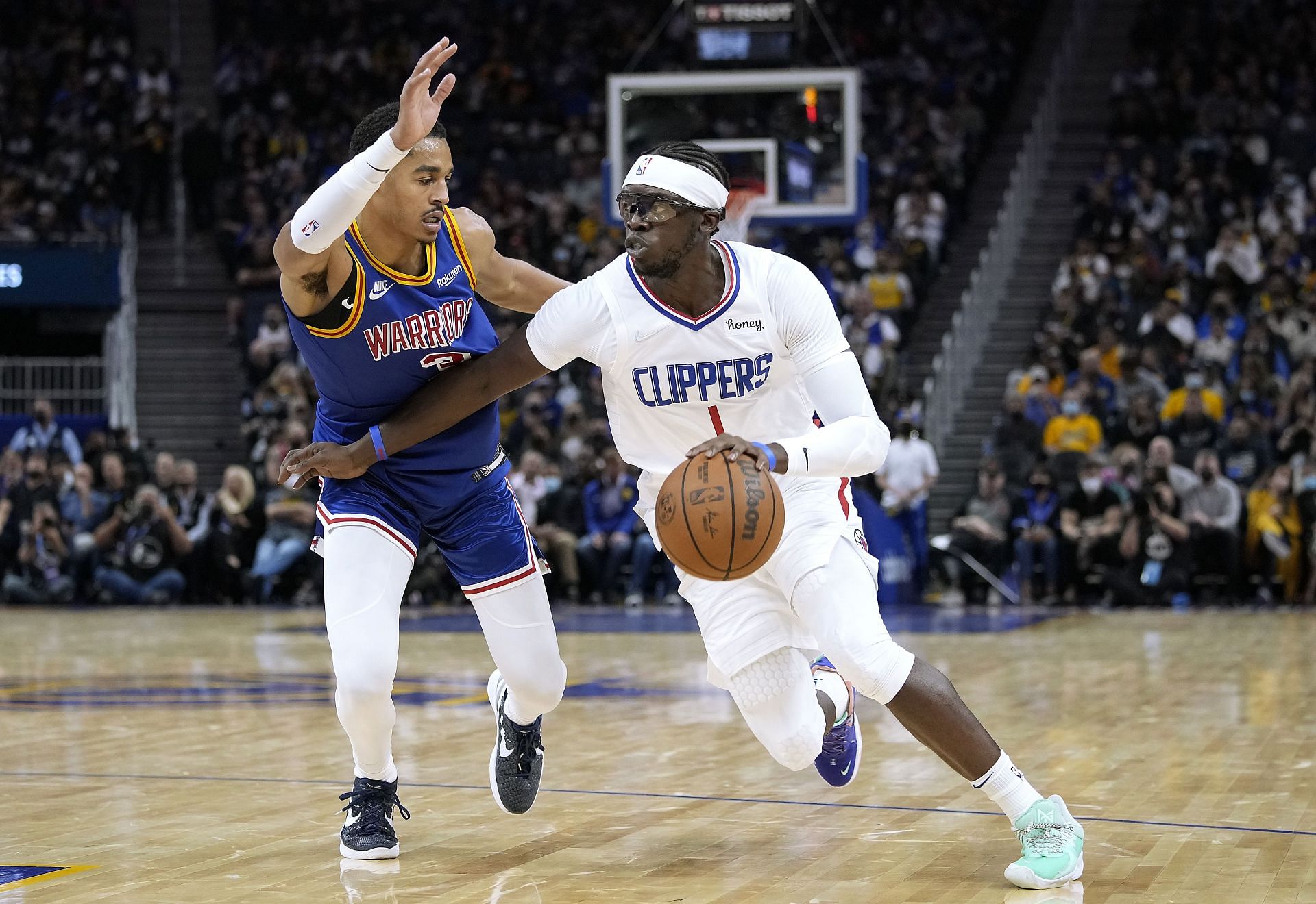 Reggie Jackson #1 of the LA Clippers drives on Jordan Poole #3 of the Golden State Warriors during the third quarter at Chase Center on October 21, 2021 in San Francisco, California.