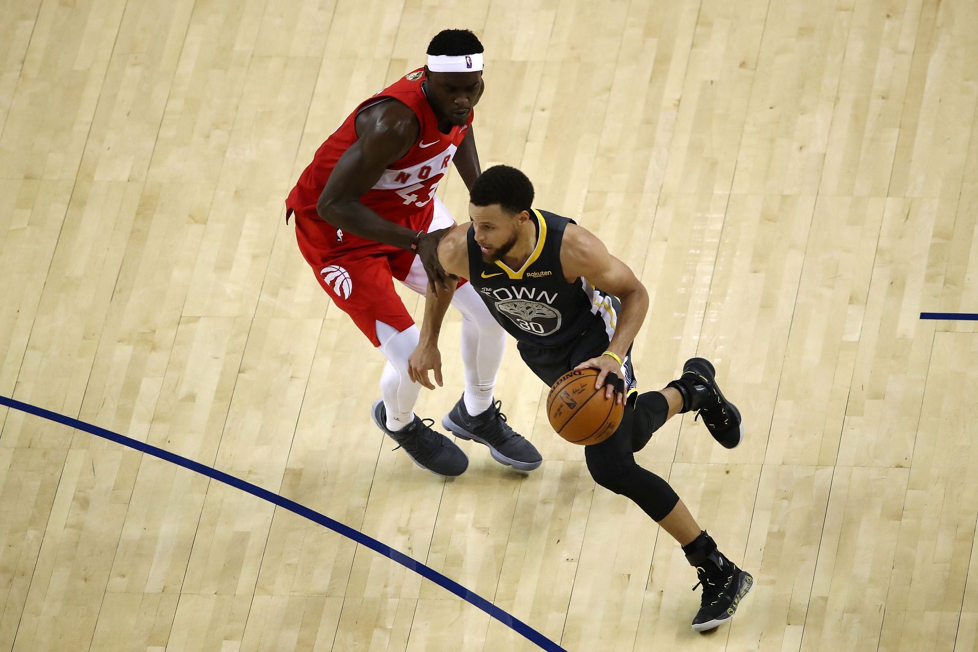 Stephen Curry of the Golden State Warriors drives past Toronto Raptors&#039; Pascal Siakam.