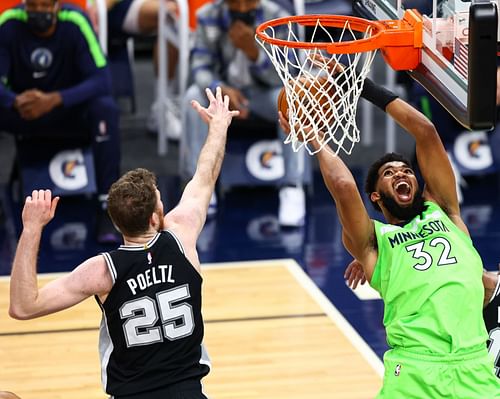 Jakob Poeltl of the San Antonio Spurs and Karl-Anthony Towns of the Minnesota Timberwolves