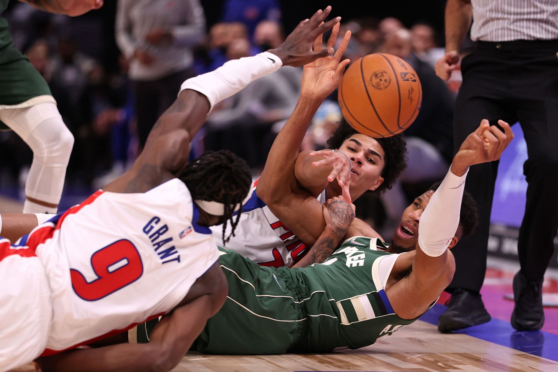 Detroit Pistons players fight to recover the ball in a game against the Milwaukee Bucks