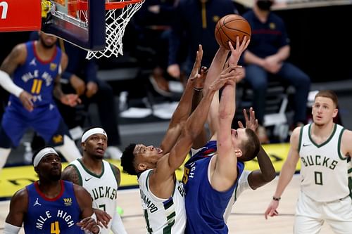 Giannis Antetokounmpo of the Milwaukee Bucks stops Nikola Jokic of the Denver Nuggets.