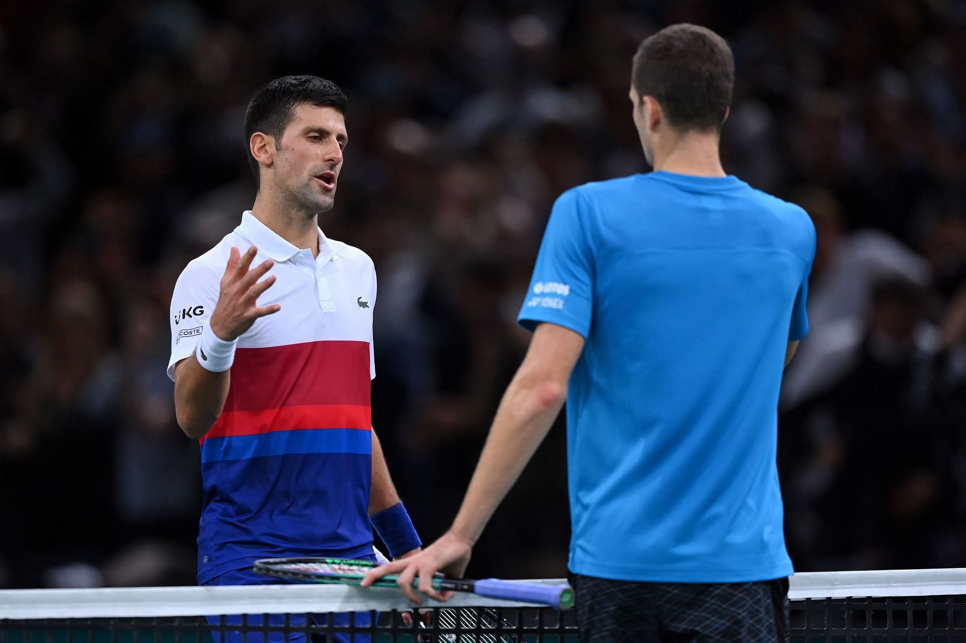 Noavk Djokovic and Hubert Hurkacz sharing an exchange at the net following their encounter in the 2021 Paris Masters
