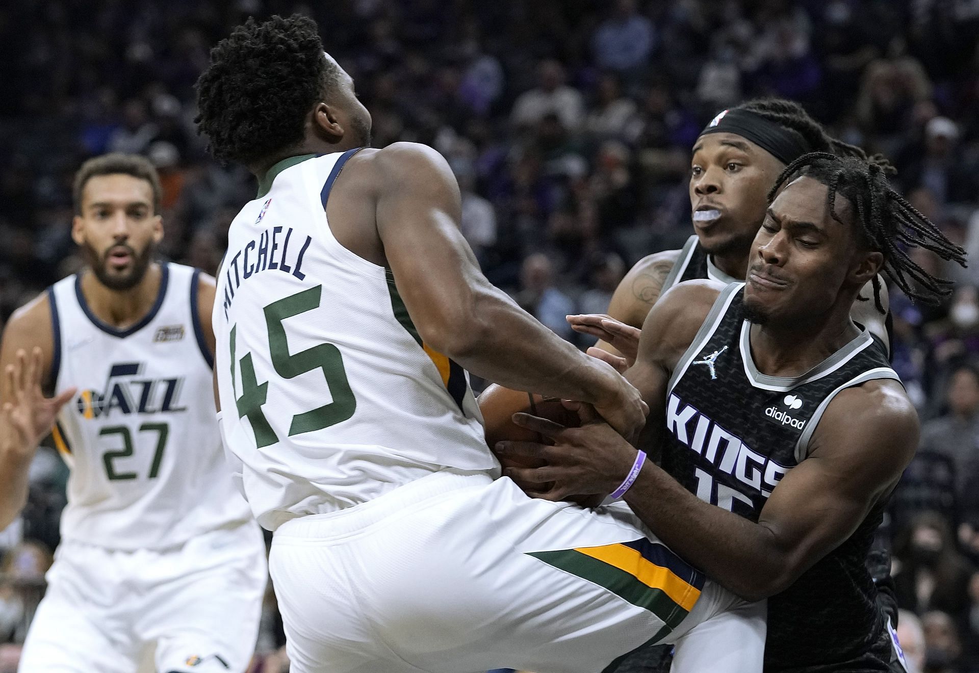 Davion Mitchell of the Sacramento Kings tries to steal the ball from Utah Jazz&#039;s Donovan Mitchell.