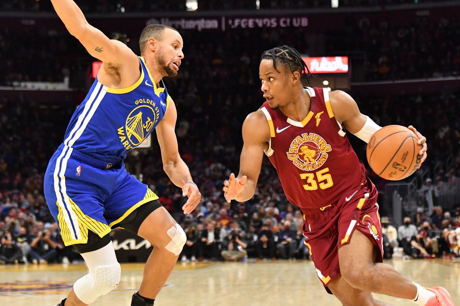 Stephen Curry attempts to stop Isaac Okoro from driving to the basket