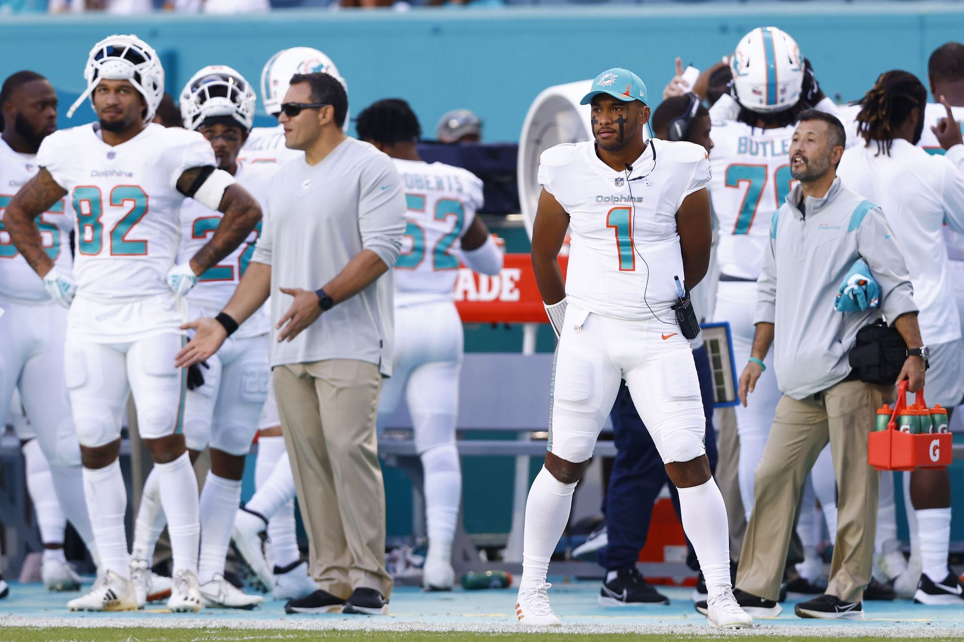 An NFL waterboy standing next to Miami Dolphins quarterback Tua Tagovailoa