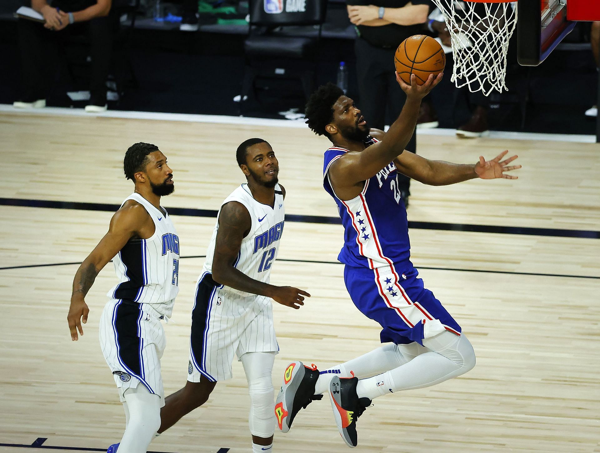 Orlando Magic players watch on as Joel Embiid of the Philadelphia 76ers lays it in
