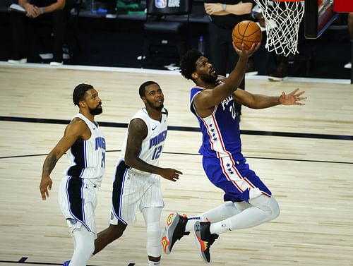 Orlando Magic players watch on as Joel Embiid of the Philadelphia 76ers lays it in