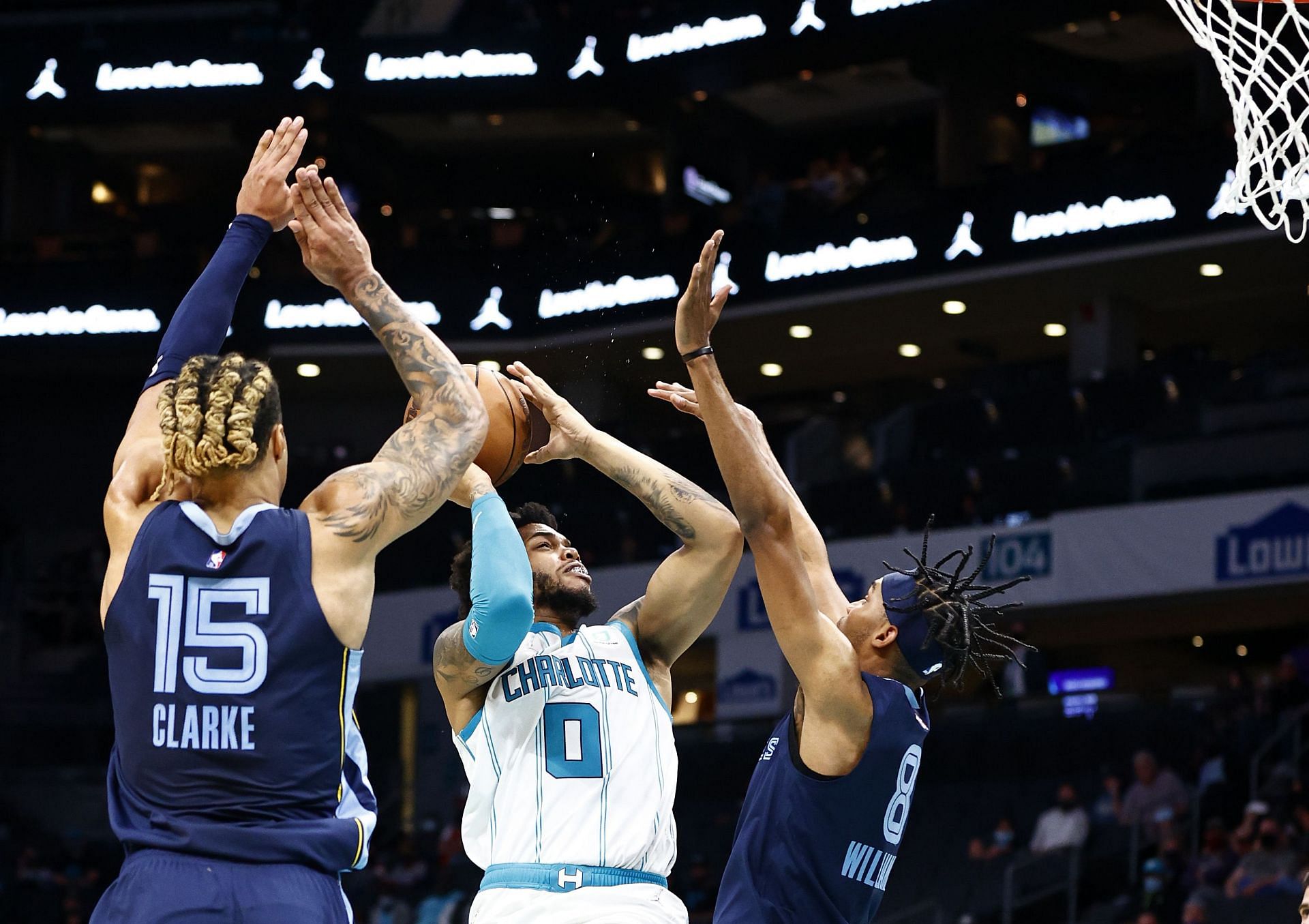 Miles Bridges of the Charlotte Hornets takes on two players of the Memphis Grizzlies.