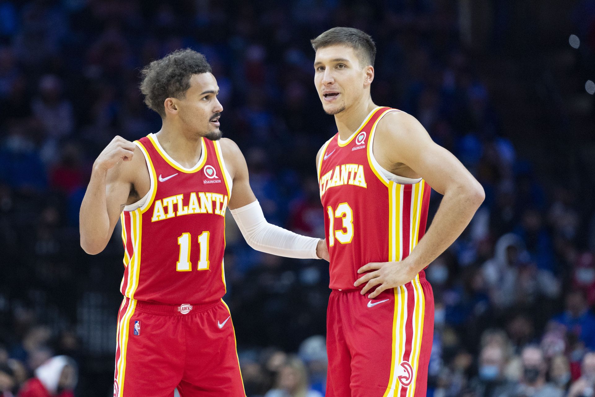 Trae Young in conversation with Bogdan Bogdanovic at an Atlanta Hawks game