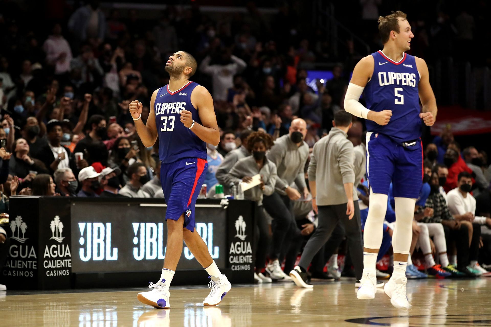 Nicolas Batum (left) and Luke Kennard (right) react to a play