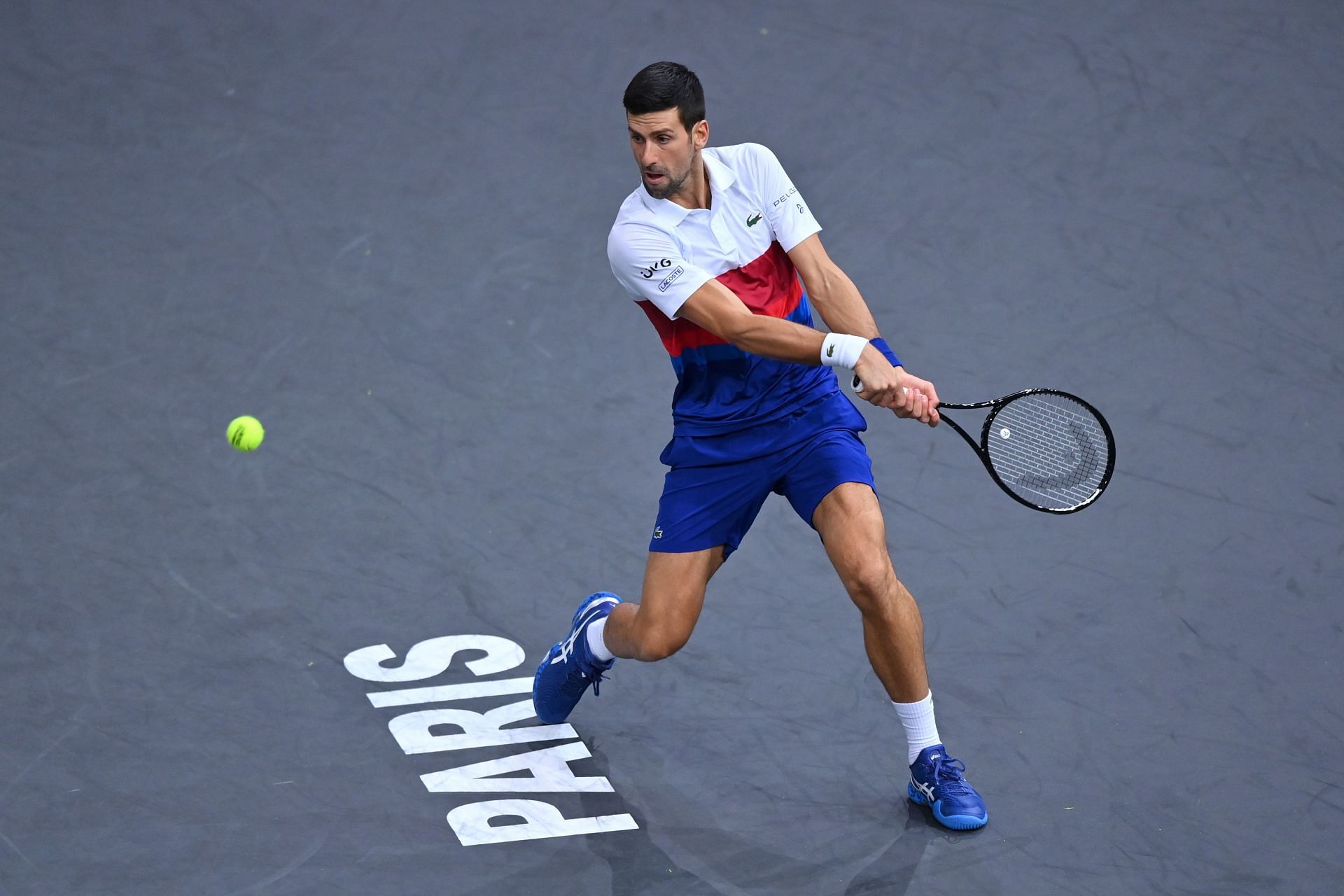 Novak Djokovic prepares to strike a backhand against Taylor Fritz