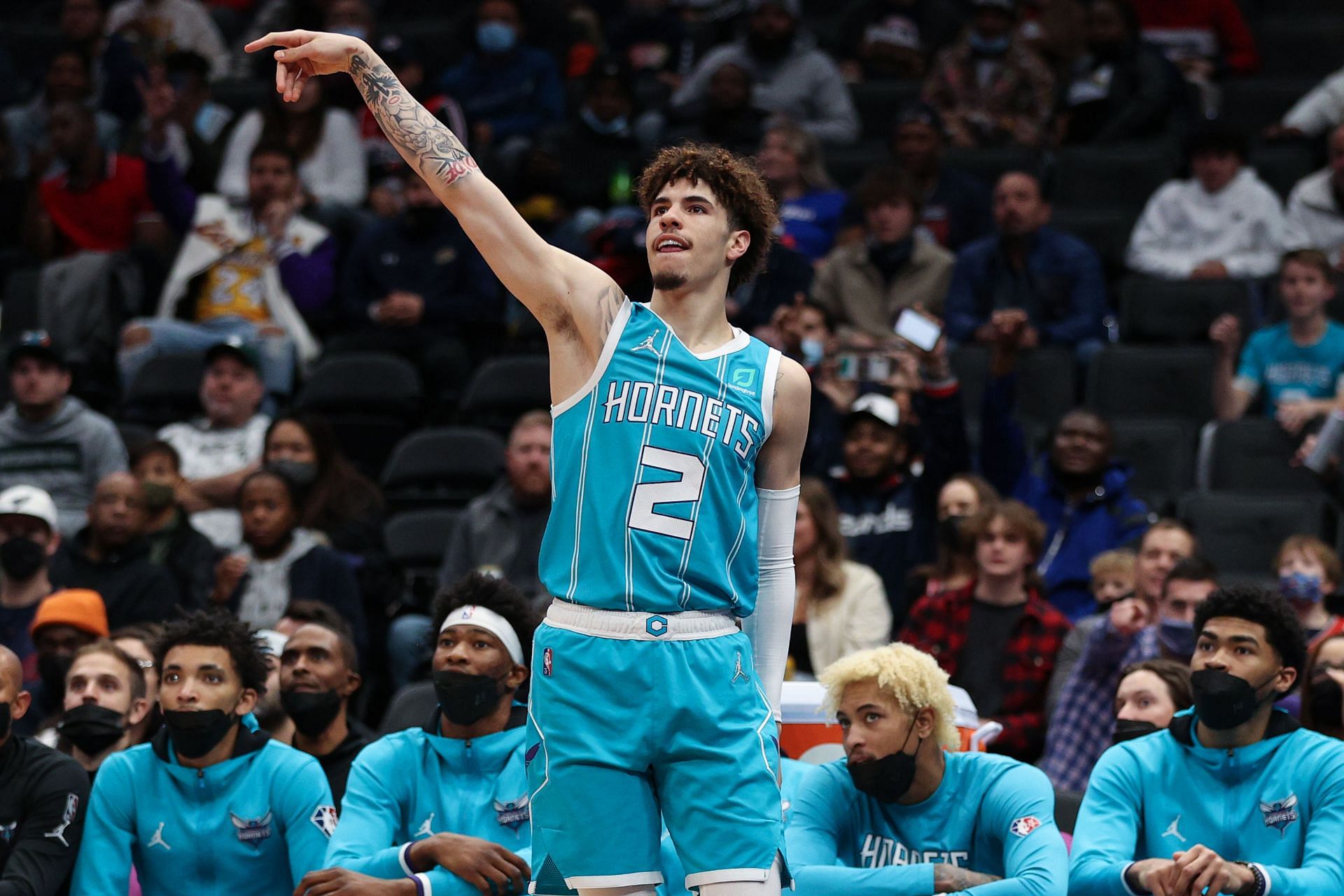 LaMelo Ball attemps a jump shot in front of the Charlotte Hornets&#039; bench