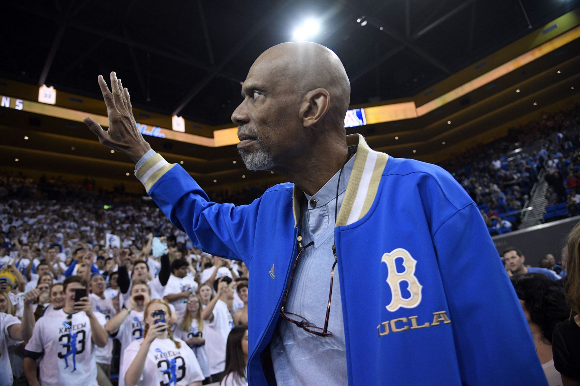 Kareem Abdul-Jabbar waves to fans as he arrive to attend the UCLA Bruins and Arizona Wildcats college basketball game